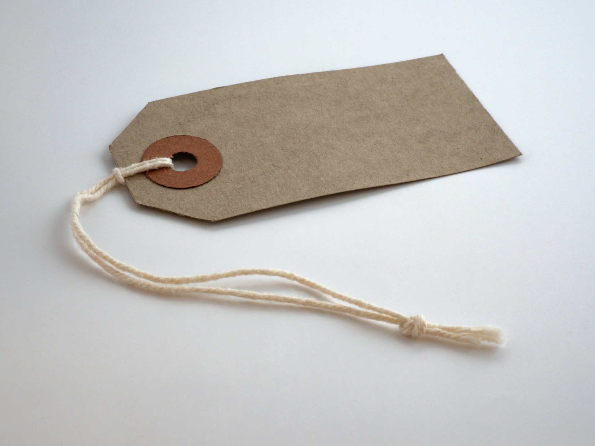 a brown paper price tag with a white string